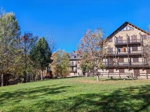 a large house on top of a grassy hill at Tranquilidad en apartamento rústico con parking - Aigüestortes 3 in Pla de l'Ermita