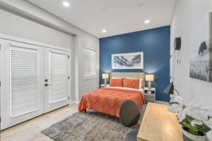 a bedroom with a bed and a blue wall at Elegant 2BD Townhome 7TH St Walkable in Fort Worth