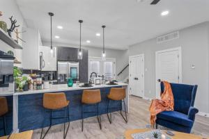 a kitchen with a blue counter and some chairs at Elegant 2BD Townhome 7TH St Walkable in Fort Worth