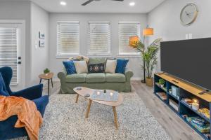 a living room with a couch and a flat screen tv at Elegant 2BD Townhome 7TH St Walkable in Fort Worth