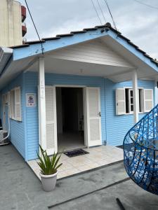 a blue house with a porch and a door at Casa na Beira Mar Continental in Florianópolis
