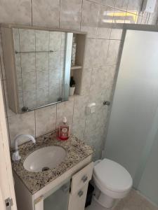 a bathroom with a sink and a toilet and a mirror at Casa na Beira Mar Continental in Florianópolis +26 photos