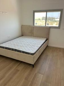 a bedroom with a bed in a room with a window at Yarin's apartment in Qiryat Shemona