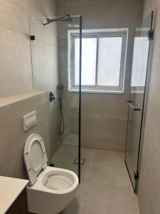 a bathroom with a toilet and a glass shower at Yarin's apartment in Qiryat Shemona