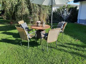 Una mesa y sillas con una sombrilla en un patio. en Ferienwohnung Idyll Mit Loggia Und Garten, en Welferode