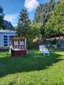 Un banco sentado en un patio al lado de un banco en Ferienwohnung Idyll Mit Loggia Und Garten, en Welferode
