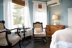 a bedroom with a bed and a table and chairs at The Inn At The Bridge in Northville