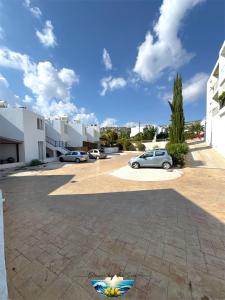 a parking lot with cars parked in a courtyard at Cozy Escape in Peyia, Sea Caves in Peyia