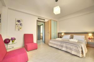 a bedroom with a bed and a red chair at Sirocco in Kissamos +20 photos