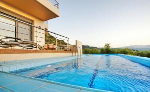 a swimming pool in front of a house at Sirocco in Kissamos