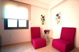 two red chairs in a room with a window at Sirocco in Kissamos +20 photos