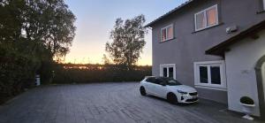 a white car parked in front of a house at Casa Botanica Boho Chic in Ostia Antica