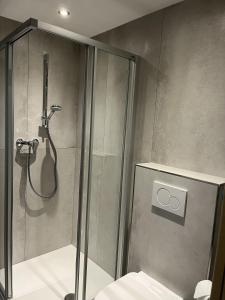 卡普伦Appartement 16 - Haus Voglreiter的带玻璃门淋浴间的浴室