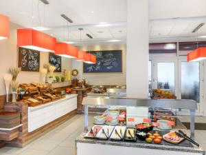 布达佩斯Ibis Budapest Citysouth的餐厅厨房，配有摆放食物的柜台