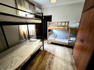 a room with two bunk beds and a window at Good nights in Tbilisi City +12 photos