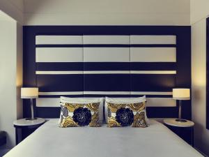 a bedroom with a large bed with two lamps at Mövenpick Hotel Auckland in Auckland