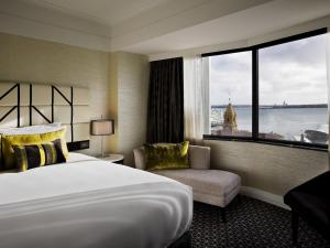 a hotel room with a large bed and a window at Mövenpick Hotel Auckland in Auckland