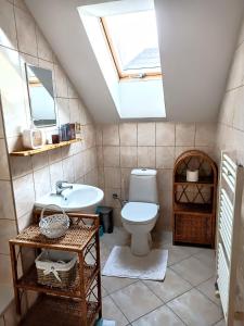 a bathroom with a toilet and a sink and a skylight at Privat Mária in Liptovský Ján