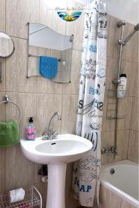 a bathroom with a sink and a shower curtain at Cozy Escape in Peyia, Sea Caves in Peyia