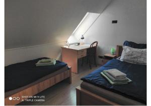 a small room with two beds and a desk with a desk at BJ szállás in Zalaegerszeg