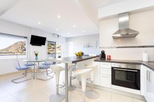 a kitchen with white cabinets and a table and chairs at Salitre - Armonía Park, Bajamar in La Laguna