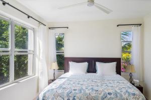 Un dormitorio con una cama grande con dos ventanas. en Wyakha 2 Ocean View, en Long Bay Hills