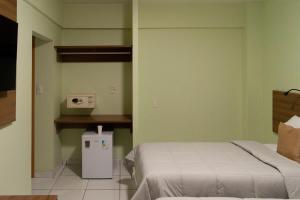 1 dormitorio con 1 cama y 1 mesa con microondas en Belém Soft Hotel, en Belém 72 fotos más