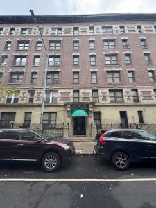 two cars parked in a parking lot in front of a building at Central Park Northwest Corner - Harlem in New York