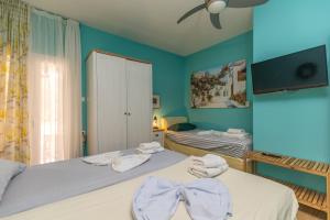 a bedroom with two beds with towels on them at Olive House in Kalamaki