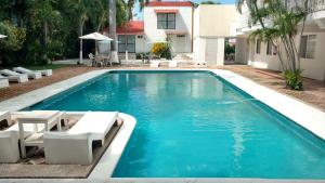 a swimming pool with chairs and a house at Hotel Olinalá Diamante in Acapulco