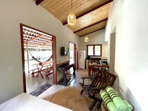 a room with a bed and a living room with a table at Pipa Moaina Hale in Pipa
