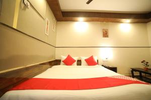 a bedroom with a large bed with red pillows at Hotel O Vip in Kota