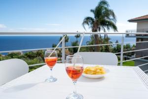 zwei Gläser Wein und eine Schüssel Essen auf dem Tisch. in der Unterkunft GiuMar Apartments Aci Trezza in Aci Catena