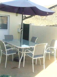 a table and chairs with an umbrella on a patio at Chez Béa in Pleumartin