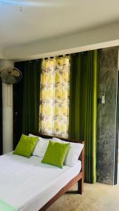 a bed with green and white pillows in a room at Homestead Villa-Polwatta in Welihinda +19 photos