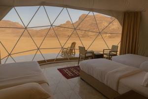 ein Zimmer mit zwei Betten und Blick auf die Wüste in der Unterkunft Waseem luxury camp in Wadi Rum