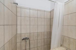 a bathroom with a shower with a shower curtain at Olive House in Kalamaki