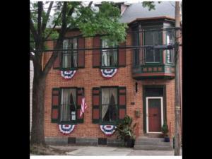a brick building with american flags on the windows at Langdon Hill House in Gettysburg