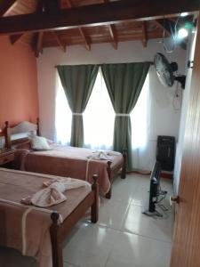 una camera con due letti, una TV e finestre di Divina Providencia a Merlo Altre 7 foto