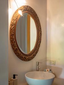 ein Badezimmer mit Waschbecken und Spiegel an der Wand in der Unterkunft La Foresteria at Casaforte Bergum by the Gates of Cividale del Friuli 