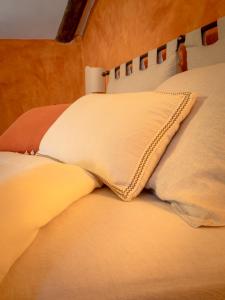 ein Bett mit zwei Kissen darauf in der Unterkunft La Foresteria at Casaforte Bergum by the Gates of Cividale del Friuli 