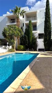 a swimming pool in front of a building at Cozy Escape in Peyia, Sea Caves in Peyia