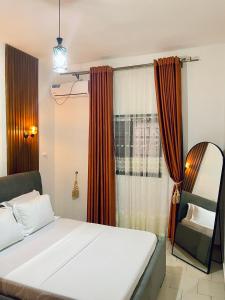 Un dormitorio con una cama y un espejo y una ventana. en JAMARI Home, en Bonabéri