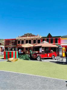 Ein roter Lieferwagen parkte vor einem Gebäude mit Regenschirmen. in der Unterkunft Casa Veta Corona Tlalpujahua in Tlalpujahua