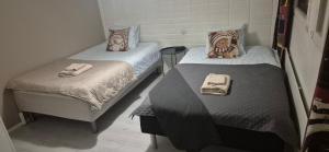 two twin beds in a small room with towels on them at Tilava uudistettu perheasunto in Rovaniemi
