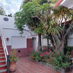 a house with trees and flowers in front of it at La Vecindad del Sol Depto G in Miramar