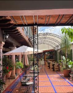 an outdoor patio with tables and umbrellas and chairs at hotel gardenias in Pátzcuaro