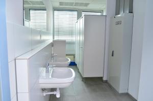 a bathroom with two sinks and two toilets at Xenon hostels in Dreieich +51 photos