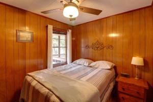 a bedroom with a bed with a ceiling fan and a window at Pet-Friendly Cabin with Designated Boat Slip! in Fairfield Bay