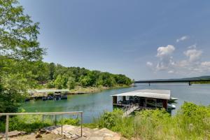 a boat on a river with a bridge in the background at Pet-Friendly Cabin with Designated Boat Slip! in Fairfield Bay